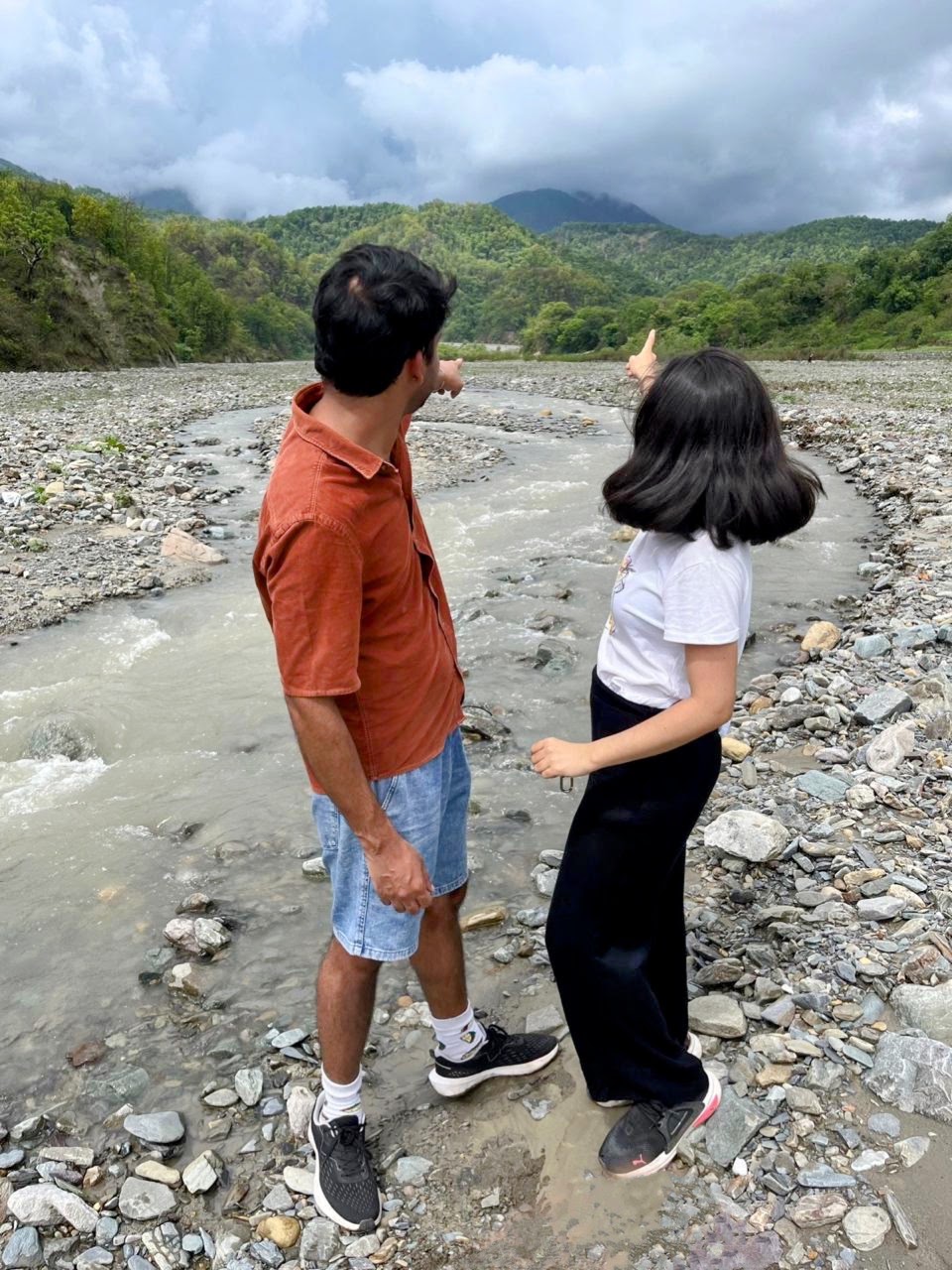 Two guests exploring beside the mountain stream